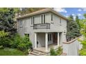 Stunning two-story home with gray stucco, clay tile roof, front porch, and second story balcony at 600 Vine St, Denver, CO 80206