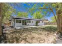 Large backyard with mature trees and a concrete patio, perfect for entertaining at 1486 S Kingston St, Aurora, CO 80012