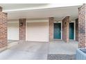 Attached garages and covered parking with brick accents and exterior doors at 2154 Concord Ln, Superior, CO 80027