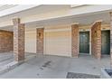 Covered garage entrance with brick pillars and a convenient doorway nearby at 2154 Concord Ln, Superior, CO 80027