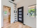 Bright foyer features hardwood floors, modern front door, and decorative ladder at 2849 S Bannock St, Englewood, CO 80110