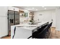 Bright kitchen with a large island, modern appliances, white cabinets, and stylish open shelving at 210 E Graves Ave, Centennial, CO 80121