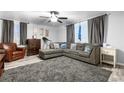 Living room with sectional sofa, wood-look walls, and large windows at 1190 Elmira St, Aurora, CO 80010