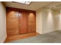 Condo hallway with wood accent wall and carpeting leading to unit 412 at 191 Clayton Ln # 402, Denver, CO 80206