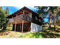 Exterior view of a hillside home showcasing a large deck and a mix of wood and painted siding at 7105 Flagstaff Rd, Boulder, CO 80302