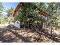 Exterior view of a charming cabin with a spacious wooden deck and surrounding natural landscape at 7105 Flagstaff Rd, Boulder, CO 80302