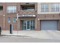 The Dakota apartment building entrance with glass doors and a garage exit only at 1441 Central St # 209, Denver, CO 80211