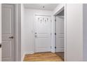 Apartment entry with a white door, hardwood floors, and coat hooks at 1441 Central St # 209, Denver, CO 80211