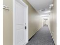 Hallway with neutral paint, gray carpet, and door to unit 209 on the left at 1441 Central St # 209, Denver, CO 80211