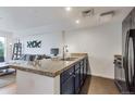 Open kitchen with granite countertops overlooking living area, next to a black refrigerator at 1441 Central St # 209, Denver, CO 80211