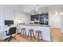 Modern kitchen features granite counters, stainless appliances and wooden barstools at the breakfast bar counter at 1441 Central St # 209, Denver, CO 80211