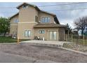 Side exterior of a two-story home with a small patio and brick accents at 1123 S Quince Way, Denver, CO 80231