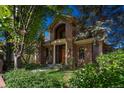 Stately brick home with a beautiful arched entryway surrounded by mature landscaping at 465 Monroe St, Denver, CO 80206