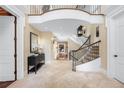 Bright and airy foyer with an elegant staircase and travertine floors creates a welcoming entrance at 465 Monroe St, Denver, CO 80206