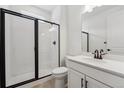 Modern bathroom with a glass-enclosed shower, sleek black fixtures, and a white vanity with countertop at 7036 E 126Th Pl, Thornton, CO 80602