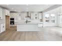 Spacious kitchen features white cabinets, stainless steel appliances, and an island with room for seating at 7036 E 126Th Pl, Thornton, CO 80602
