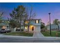 Charming two-story home with a one car garage, manicured lawn, and lovely dusk sky backdrop at 4347 W Kenyon Ave, Denver, CO 80236