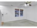 Spacious living room with ample natural light and a ceiling fan, providing a comfortable and inviting atmosphere at 4347 W Kenyon Ave, Denver, CO 80236