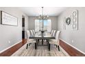 Elegant dining room with wood floors, decorative accents, and seating for eight at 4009 Manorbrier Cir, Castle Rock, CO 80104