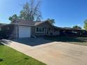 Exterior view featuring a ranch-style home, concrete driveway, attached one car garage and a front yard with mature trees at 841 S 6Th Ave, Brighton, CO 80601