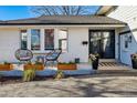 Inviting front porch with seating, planters, modern door with decor, and well-maintained facade at 6787 E Exposition Ave, Denver, CO 80224