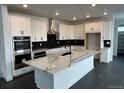 Modern kitchen with marble countertops, stainless steel appliances, large island, and ample cabinet space at 16529 Black Rose Cir, Parker, CO 80134