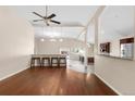 Open-concept living room featuring hardwood floors, a ceiling fan, and a breakfast bar area at 1249 S Irving St, Denver, CO 80219