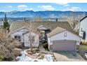 Beautiful aerial view of a single-story home with mountain views, a two-car garage, and landscaped yard at 353 Oxbow Dr, Monument, CO 80132