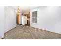 Bright dining area with updated lighting, neutral carpet, and a view into the kitchen, perfect for entertaining at 922 S Dearborn Way # 8, Aurora, CO 80012