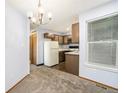Bright dining area with updated lighting, neutral carpet, and a view into the kitchen, perfect for entertaining at 922 S Dearborn Way # 8, Aurora, CO 80012