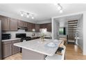 Bright kitchen featuring wood floors, an island, stainless appliances and access to stairs at 8979 Field St # 27, Westminster, CO 80021