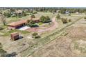 Expansive aerial view of a secluded home with mature trees, a long driveway, and outbuildings on acreage at 811 Panorama Dr, Elizabeth, CO 80107