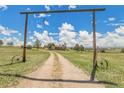 Inviting gravel driveway framed by a decorative entrance, leading to a secluded home on a sprawling property at 811 Panorama Dr, Elizabeth, CO 80107