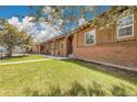 Charming brick home featuring a covered front porch with ample seating and a well-manicured lawn at 811 Panorama Dr, Elizabeth, CO 80107