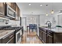 Modern kitchen featuring stainless appliances, granite counters, and dark cabinetry with an adjacent eat-in dining space at 4569 Copeland Loop # 203, Highlands Ranch, CO 80126