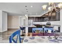 Stylish kitchen with dark cabinetry, granite counters, stainless appliances, eat-in counter, adjacent dining area at 4569 Copeland Loop # 203, Highlands Ranch, CO 80126