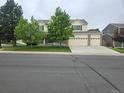 Beautiful home featuring a three-car garage, well-maintained lawn, and mature trees at 5571 S Sicily St, Aurora, CO 80015