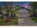 Charming home at twilight with a well-manicured lawn, concrete driveway, and inviting curb appeal at 4320 Snowbird Ave, Broomfield, CO 80020