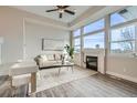 Bright living room with fireplace, large windows, and modern decor showcasing a cozy atmosphere at 12032 Monaco St, Brighton, CO 80602