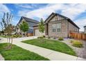 Lovely home with manicured lawn and tasteful stone accents, showcasing suburban charm and curb appeal at 5771 Slate River Pl, Brighton, CO 80601