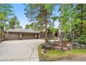 Beautiful home with an attached three car garage, large driveway and mature trees at 29432 Camelback Ln, Evergreen, CO 80439