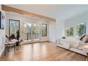 Bright bedroom with hardwood floors, access to a balcony and a picturesque view of the trees at 375 Aspen Way, Evergreen, CO 80439