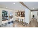 Bright dining area with a breakfast bar featuring white leather seats and modern lighting fixtures at 375 Aspen Way, Evergreen, CO 80439