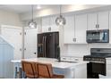 Modern kitchen with white cabinets, stainless steel appliances, a sleek island, and pendant lighting at 9768 E 62Nd Dr, Denver, CO 80238