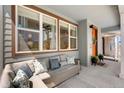 Inviting front porch featuring a comfortable outdoor sofa, stylish pillows, and a welcoming entrance at 9768 E 62Nd Dr, Denver, CO 80238