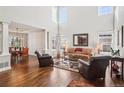Bright, airy living room featuring soaring ceilings, hardwood floors, many windows, and stylish furnishings at 16342 Parkside Dr, Parker, CO 80134