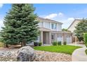 Attractive home with brick and siding, mature trees, landscaping, and a stone-lined garden at 11821 Joplin Ct, Commerce City, CO 80022