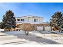 Attractive two-story home with brick accents, neat landscaping, a two-car garage, and a snow-covered front yard at 11821 Joplin Ct, Commerce City, CO 80022