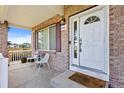 Inviting front porch with seating area, showcasing brickwork and an attractive front door at 11821 Joplin Ct, Commerce City, CO 80022