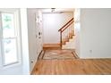 Inviting foyer with wood floors, staircase, and a view into the living area at 4753 S Gar Way, Littleton, CO 80123